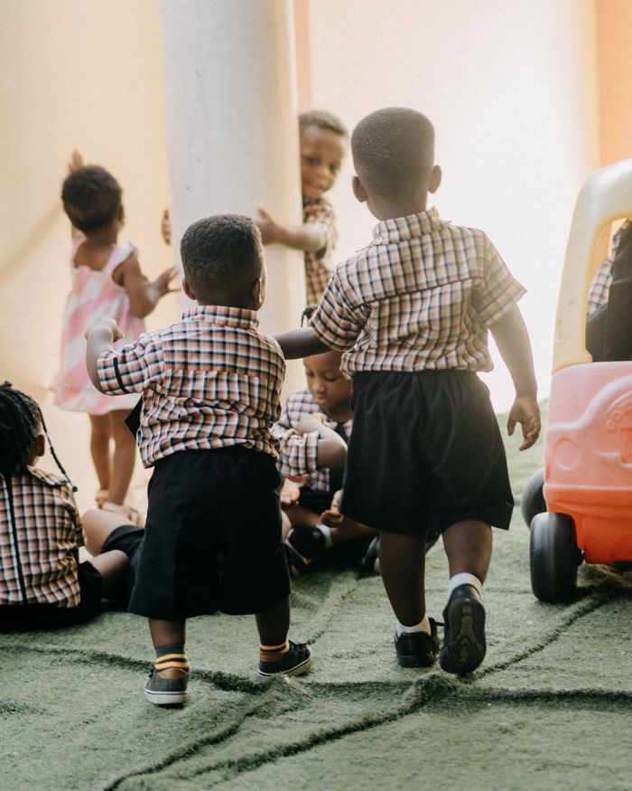 A group of young children enjoying playtime at school, dressed in uniforms.